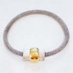 bracelet with silver round mesh band and bi-metal gold/silver bead on top