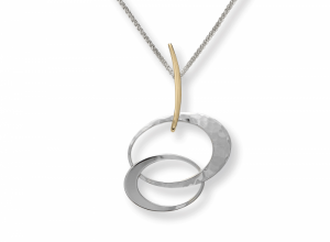 Silver and gold pendant on silver wheat chain; pendant has two silver offset interlocking ovals, suspended by a gold bar which hangs from the chain