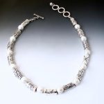 Collar style necklace with alternating silver beads which are rectangular and domed and textured oranately with silver bezel set round pearls, adjustable silver toggle clasp