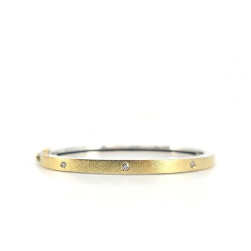 4MM. Silver hinged bangle featuring an 18k gold push button style clasp and a solid 18k gold sheet top set with 5 white diamonds 0.20ct total combined diamond weight.