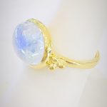 Oval Cabochon Rainbow Moonstone and 14k yellow gold ring with 3 ball accents on each side and 2mm round band