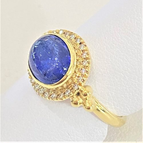 Oval cabochon Tanzanite ring with a halo of diamonds and 3 gold ball accents on either side ring with 2mm round band