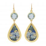 Hanging earrings with gold ear wire suspending a faceted blue topaz followed by a solid teardrop with painted blue and white flowers and gold leaf rim